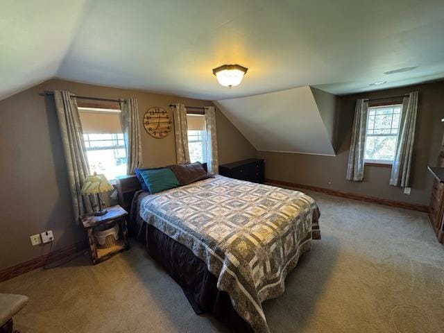 bedroom with light carpet, multiple windows, vaulted ceiling, and baseboards
