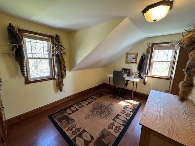 bonus room with dark wood-type flooring, baseboards, a desk, and lofted ceiling