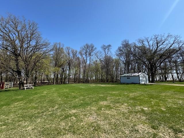 view of green lawn featuring an outbuilding