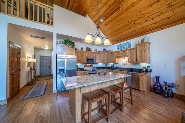 kitchen with wood finished floors, a sink, high vaulted ceiling, stainless steel appliances, and visible vents
