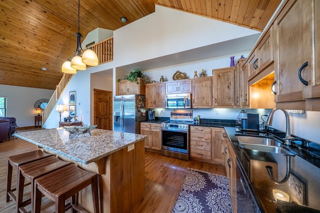 kitchen with a center island, a sink, wood ceiling, high vaulted ceiling, and appliances with stainless steel finishes