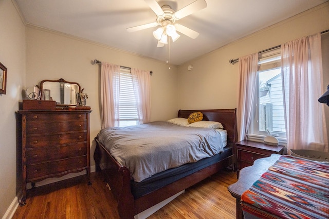 bedroom with wood finished floors, ornamental molding, and ceiling fan