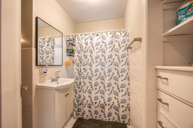 bathroom featuring tile walls, vanity, a shower with shower curtain, and tile patterned flooring