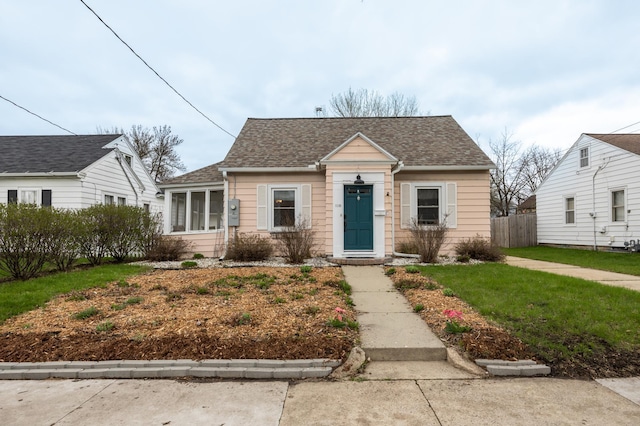 bungalow-style house with a shingled roof and a sunroom