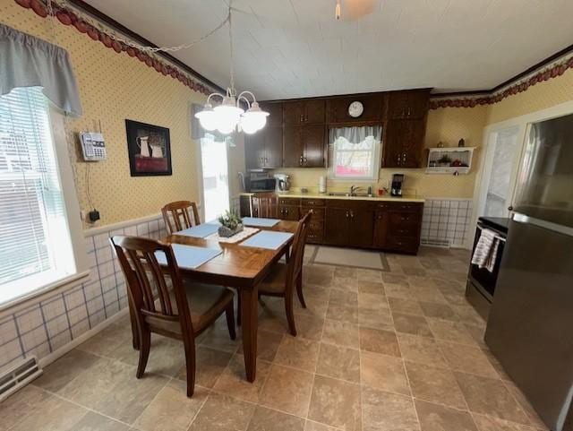 dining area with wainscoting, an inviting chandelier, wallpapered walls, and visible vents