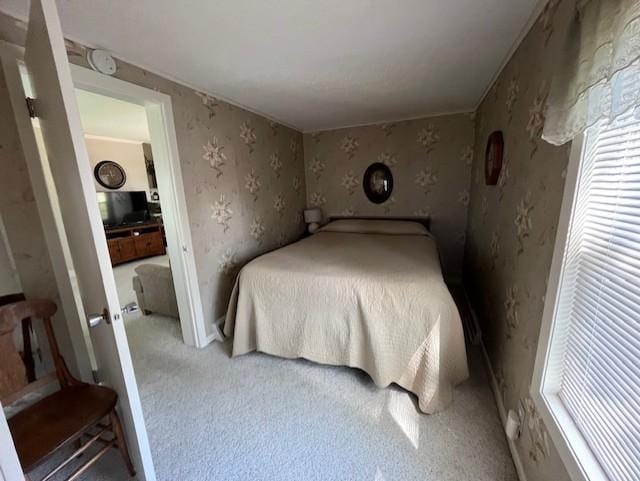 bedroom with light colored carpet and wallpapered walls