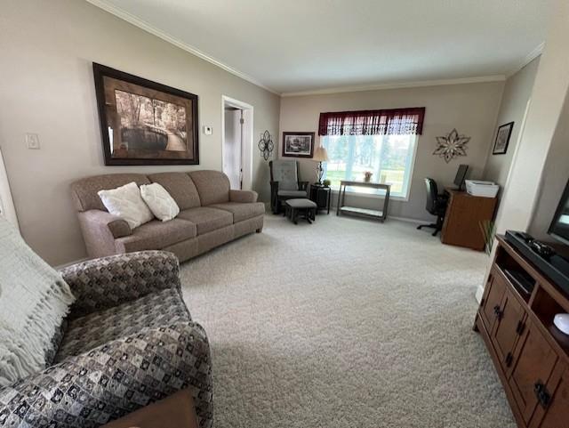 living area with baseboards, crown molding, and light colored carpet