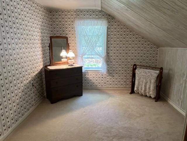 additional living space with lofted ceiling, baseboards, wallpapered walls, and carpet