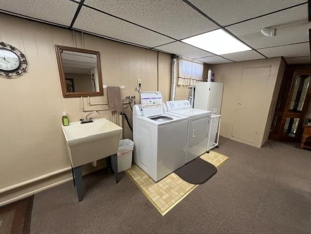 clothes washing area with washing machine and dryer, light colored carpet, and water heater