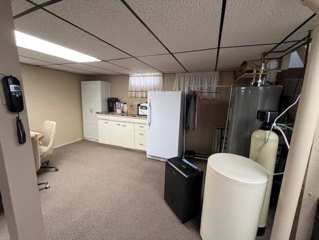 below grade area with freestanding refrigerator, water heater, a drop ceiling, and light carpet