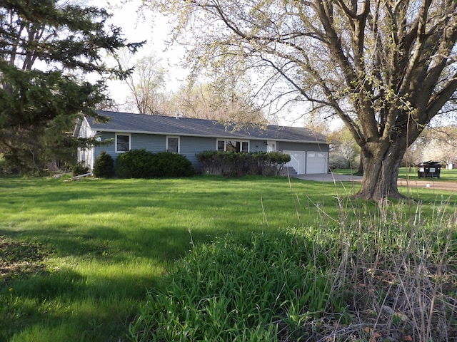 view of front of house featuring concrete driveway, a garage, and a front yard