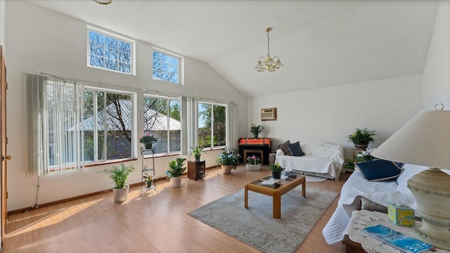 living room featuring a chandelier, wood finished floors, baseboards, a wall unit AC, and high vaulted ceiling