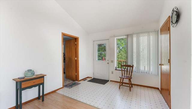 doorway featuring vaulted ceiling and baseboards