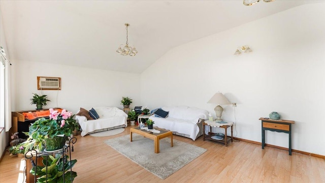 living room with vaulted ceiling, a wall mounted AC, a chandelier, and wood finished floors