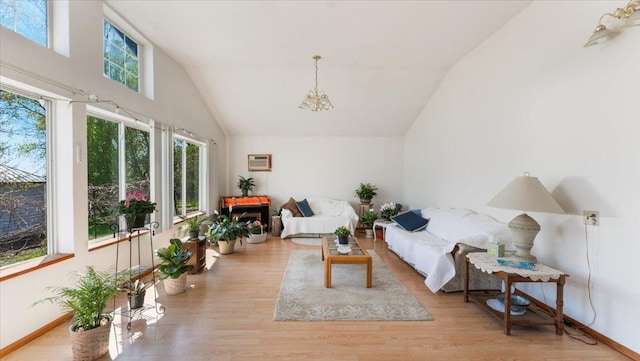 sunroom featuring lofted ceiling, a chandelier, and a wall mounted AC