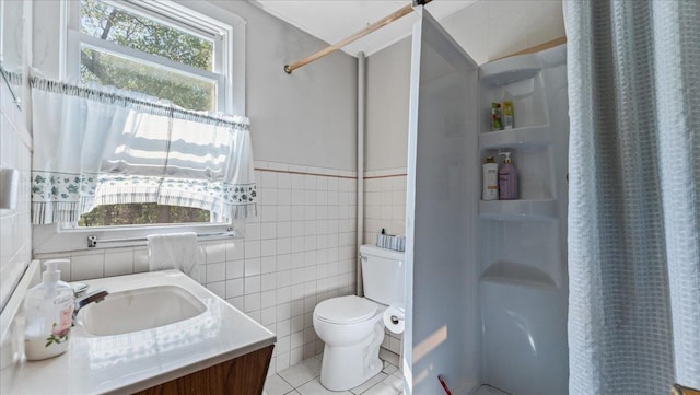 bathroom with a shower with shower curtain, toilet, tile walls, tile patterned flooring, and vanity