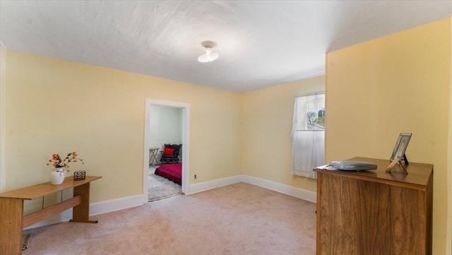 carpeted spare room featuring baseboards