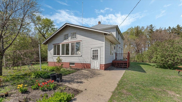 view of property exterior featuring a lawn, a chimney, crawl space, and a patio