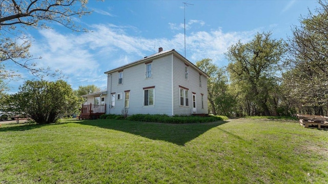 view of property exterior with a yard, a chimney, and a wooden deck