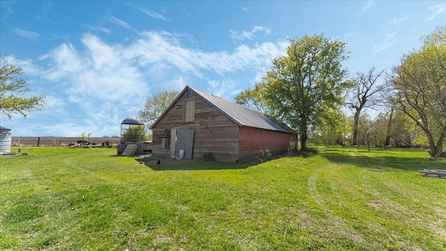 view of property exterior with a barn, a yard, and an outdoor structure