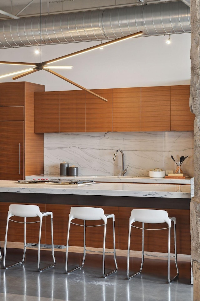 700 2nd St Unit W31, Minneapolis, MN 55401 - kitchen featuring brown cabinetry, modern cabinets, and backsplash