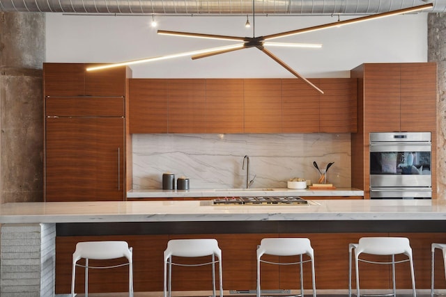 700 2nd St Unit W31, Minneapolis, MN 55401 - kitchen featuring brown cabinets, modern cabinets, stainless steel appliances, and decorative backsplash