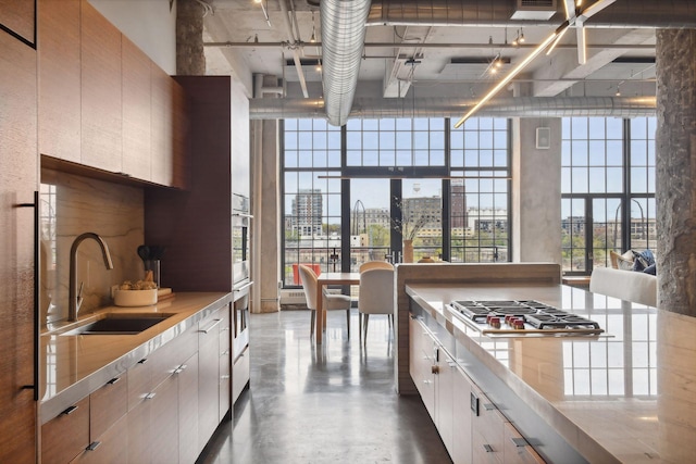 700 2nd St Unit W31, Minneapolis, MN 55401 - kitchen featuring stainless steel gas stovetop, a sink, a city view, light countertops, and concrete flooring