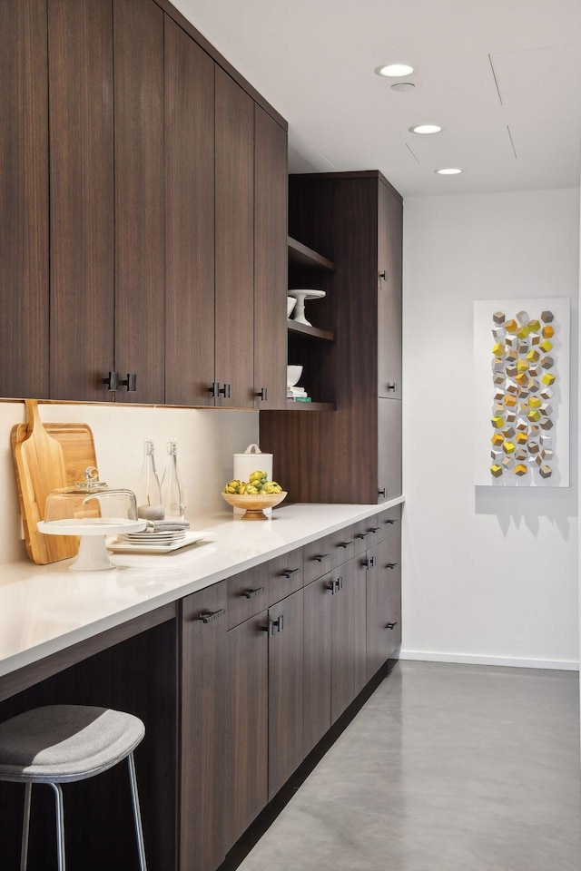 700 2nd St Unit W31, Minneapolis, MN 55401 - kitchen with recessed lighting, baseboards, dark brown cabinets, open shelves, and light countertops