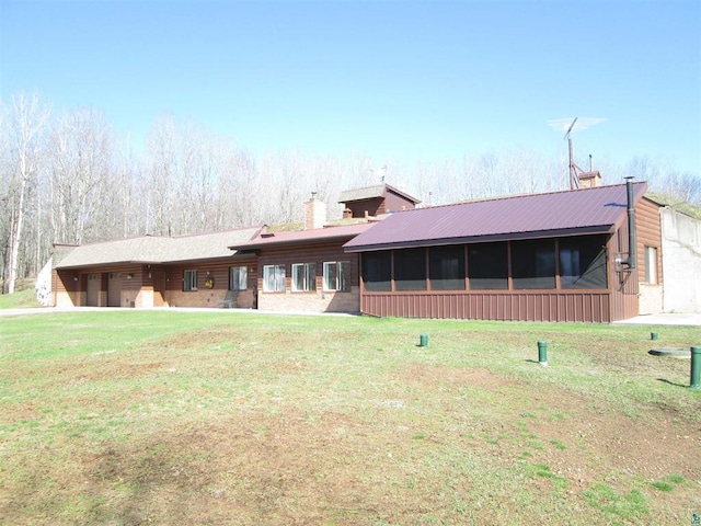 single story home featuring a front lawn, a chimney, and an attached garage