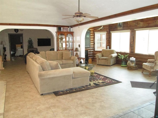 living room featuring ceiling fan, light tile patterned flooring, and arched walkways