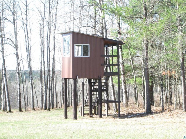 view of outdoor structure featuring stairway and a forest view