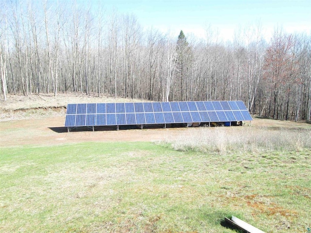 view of home's exterior with solar panels and a view of trees
