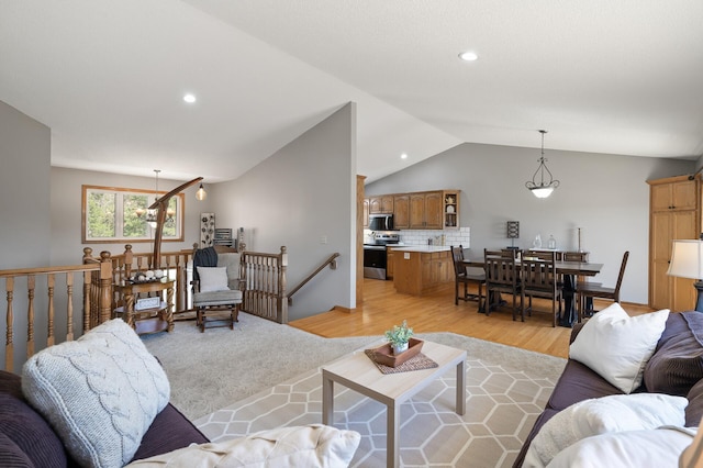living room featuring lofted ceiling, light wood-style floors, and recessed lighting