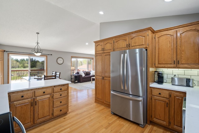 kitchen with freestanding refrigerator, light countertops, brown cabinets, and light wood-style flooring