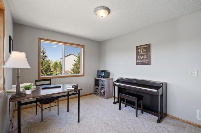 home office with light colored carpet, a textured ceiling, visible vents, and baseboards