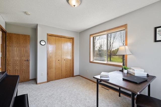 office area featuring a textured ceiling, carpet flooring, baseboards, and visible vents