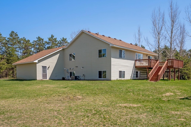 back of house with stairs, a wooden deck, and a lawn