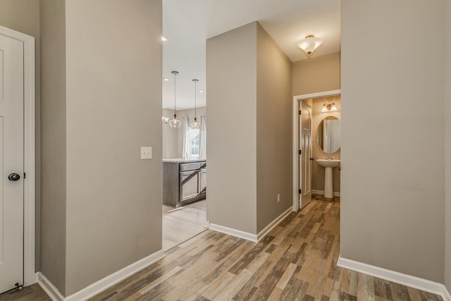 hallway with light wood finished floors and baseboards