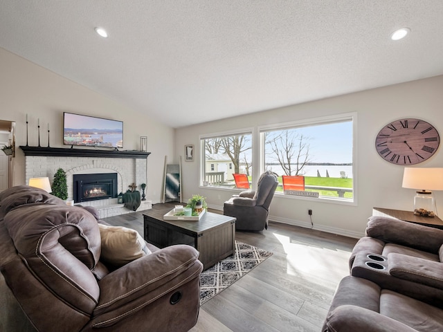 10823 Big Chip Rd NW, Brandon Twp, MN 56315 - living room with a fireplace, recessed lighting, a textured ceiling, wood finished floors, and vaulted ceiling