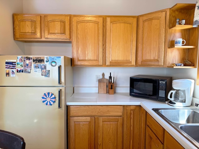 5301 Oak St, Isle, MN 56342 - kitchen featuring a sink, freestanding refrigerator, open shelves, light countertops, and black microwave