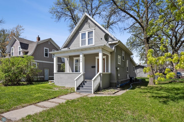 view of front of home with covered porch, a front lawn, and cooling unit