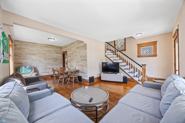 living area with stairs, wood finished floors, and baseboards