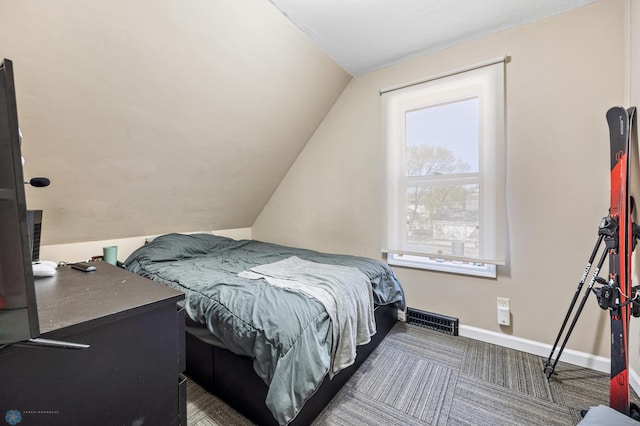 carpeted bedroom with lofted ceiling and baseboards