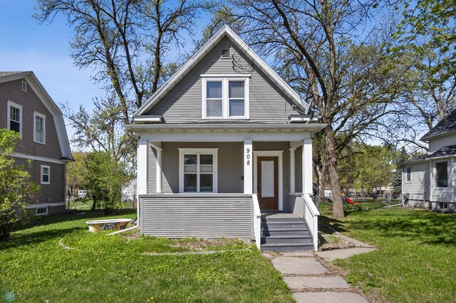 bungalow featuring a porch and a front lawn