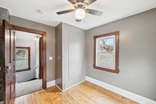 unfurnished bedroom featuring baseboards, a ceiling fan, and light wood-style floors