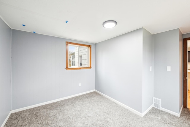 carpeted spare room with baseboards and visible vents