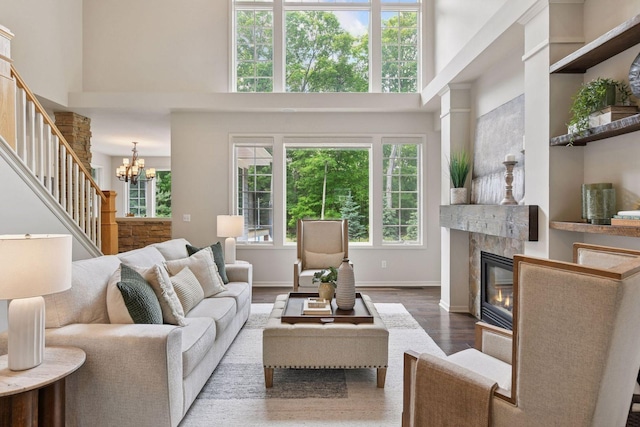 8622 French Curv, Eden Prairie, MN 55347 - living room with wood finished floors, stairs, a glass covered fireplace, a towering ceiling, and a chandelier
