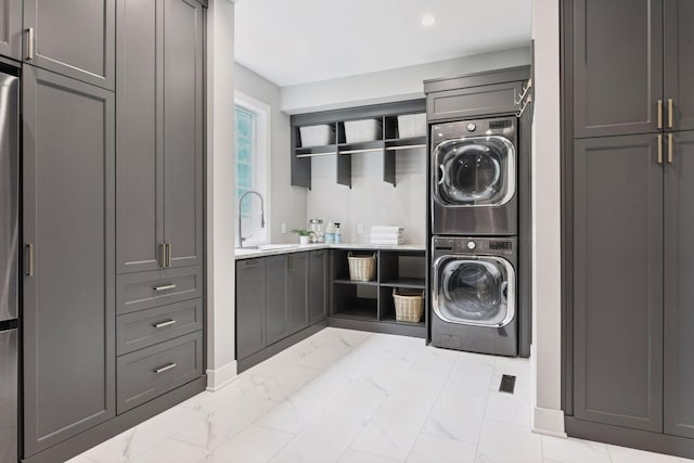 8622 French Curv, Eden Prairie, MN 55347 - laundry area with stacked washing machine and dryer, cabinet space, light marble finish floors, and baseboards