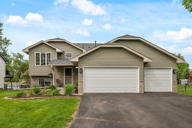 14380 Geneva Ave N, Hugo, MN 55038 - tri-level home with asphalt driveway, a garage, a front yard, a shingled roof, and brick siding