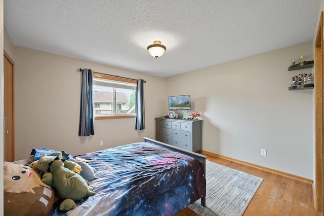 14380 Geneva Ave N, Hugo, MN 55038 - bedroom with wood finished floors, a textured ceiling, and baseboards